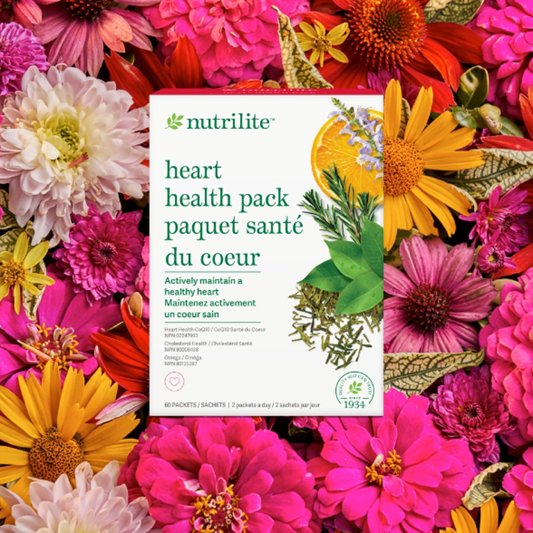Paquete para la salud del corazón Nutrilite sobre un lecho de flores rosas, rojas y naranjas