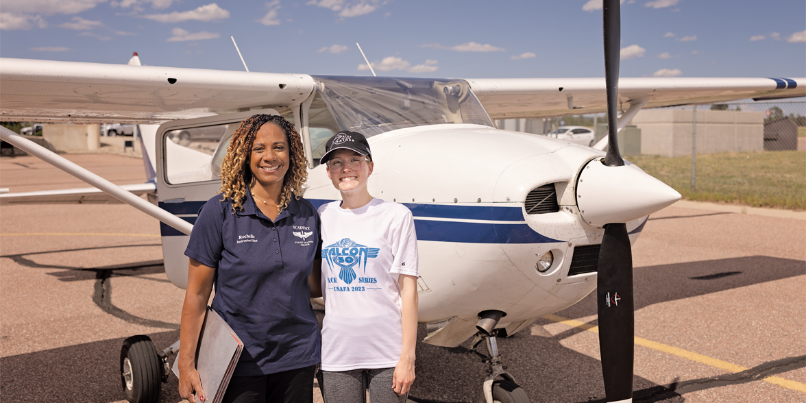 Rochelle Kimbrell pose devant un avion avec un étudiant qu’elle mentore.